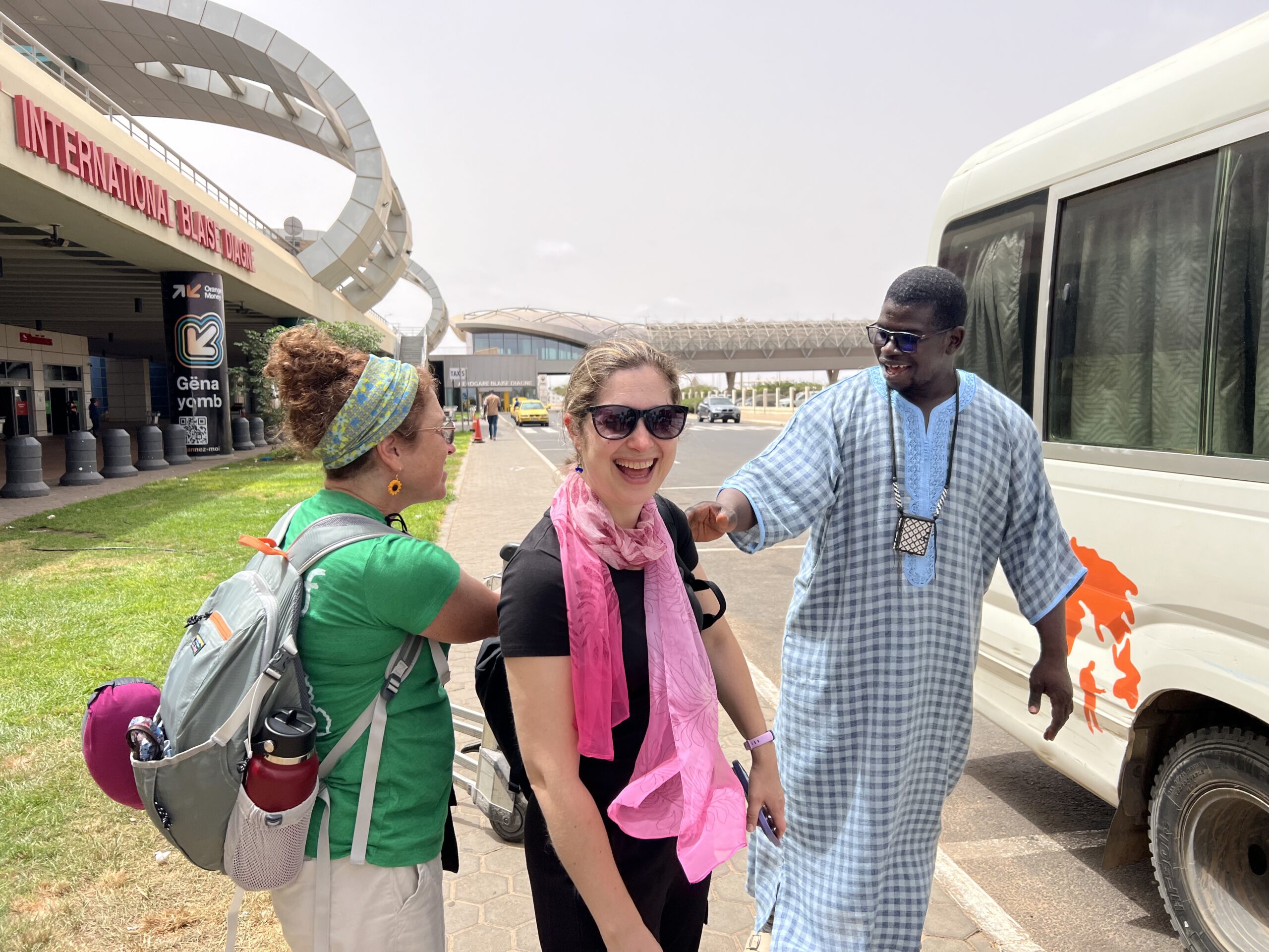 Arrival in Senegal Three people smiling and meeting each other at Dakar airport